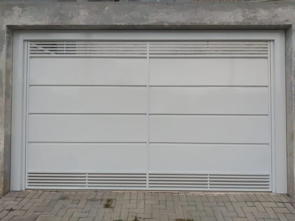 Portão basculante branco com frisos horizontais e faixas de ventilação