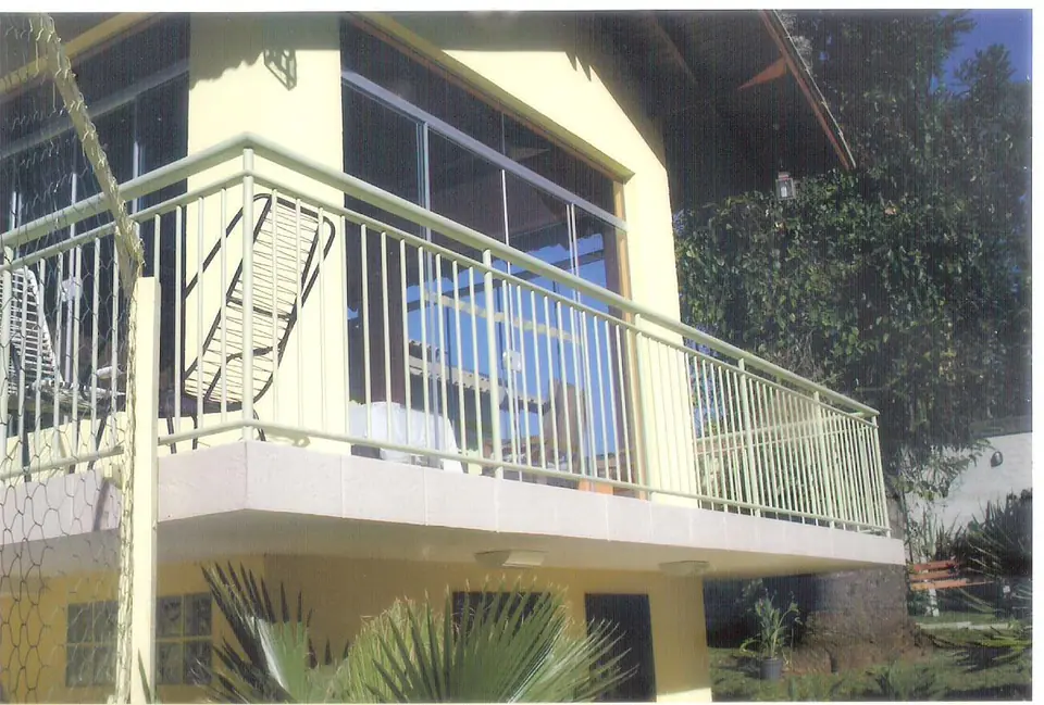 Guarda-corpo branco em varanda de casa