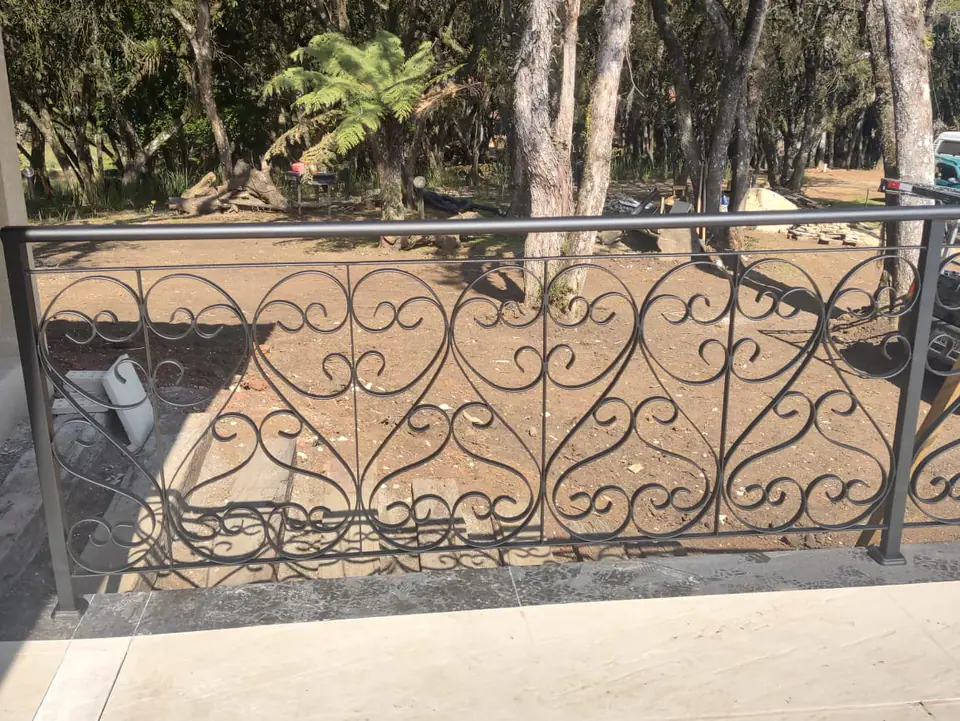 Gradil ornamental com arabescos em área externa
